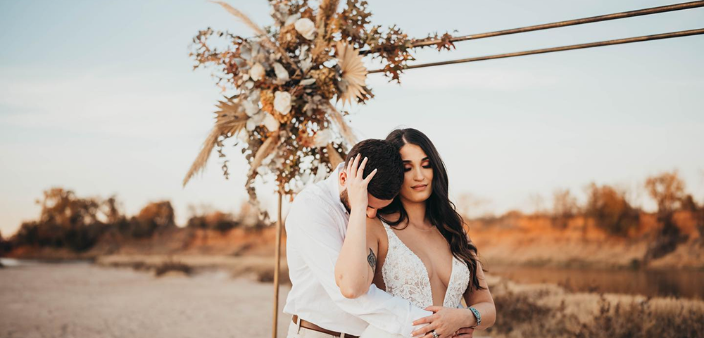 Wedding couple seated by a rustic ceremony setup